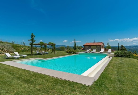 Piscina a sfioro arredata con pergola, lettini e tavolini verso il casale – Rosa dei Venti 8  
