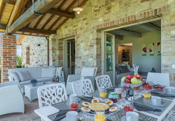 Zona relax e tavolo attrezzato per mangiare fuori sotto al portico a canto al salotto - Rosa dei Venti 8  