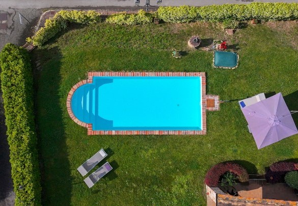 The pool with the spacious sunbathing area equipped with sunbeds, umbrella and cold water shower - San Rocco