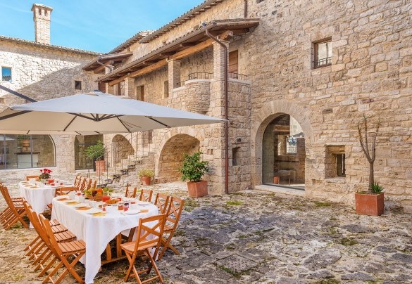 The courtyard equipped with tables, chairs and umbrellas - Santa Illuminata