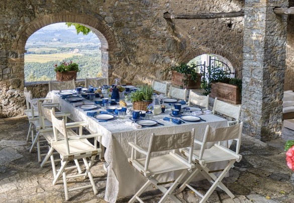 At the back is a large area with a table for outdoor dining, protected by a large umbrella - Scandelaia