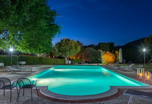 La piscina e la zona prendisole illuminate al tramonto - Tenuta Astolfi