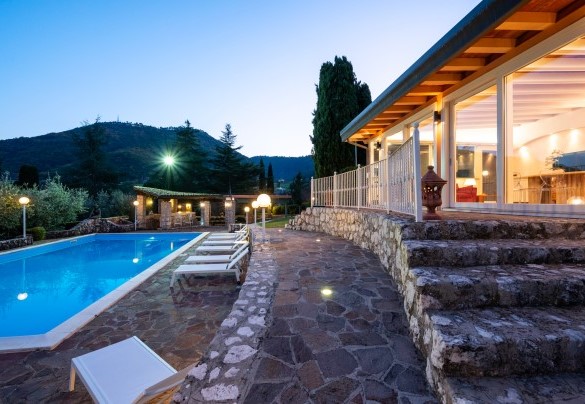 Suggestiva vista della piscina con le ampie vetrate della veranda nelle luci della sera - Tenuta Cavi