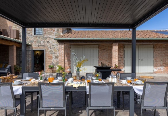 The outdoor dining area shaded by a pergola and equipped with a barbecue - Tenuta Francigena