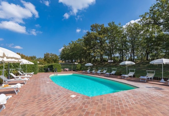 The pool and the sunbath area set up with sunbeds, umbrellas and shower - Tenuta Montiepoli 