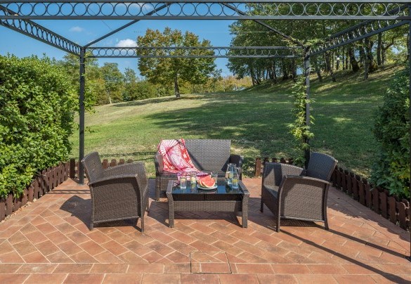 The gazebo, in the pool area, furnished with sofa, armchairs and table - Tenuta Montiepoli