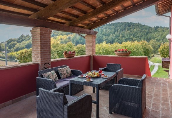 Two bedrooms share a panoramic terrace furnished with sofa, armchairs and table - Tenuta Montiepoli 