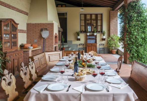Under the covered porch, a large table with benches and chairs, a large brick BBQ and the wood-burning oven will allow you to enjoy tasty outdoor lunches and dinners – Tenuta Navelli
