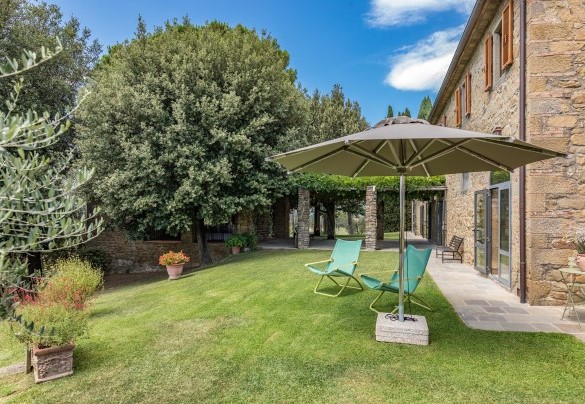 Lungo il perimetro del giardino, si alternano zone a prato e superfici in pietra, costellate da alberi da frutto e fioriture - Tenuta Sagherina