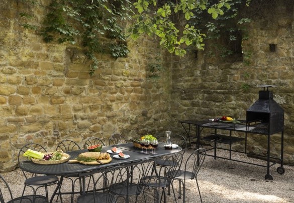 Superficie terrazzata che accoglie un tavolo con sedie e barbecue - Torre di Paciano