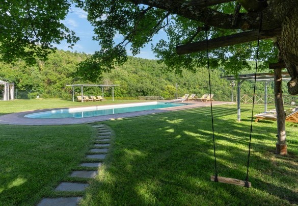 The big panoramic pool, right in the middle of a vast grassy surface - Torre Ginestre