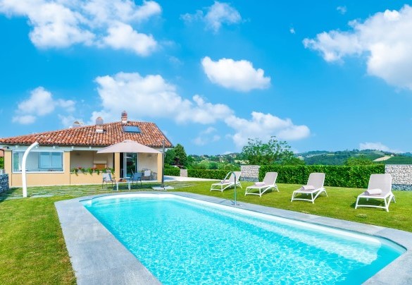 La bella piscina con il getto di acqua a cascata, le bocchette per l’idromassaggio e la doccia esterna con acqua calda e fredda - Villa Tramonto Albese