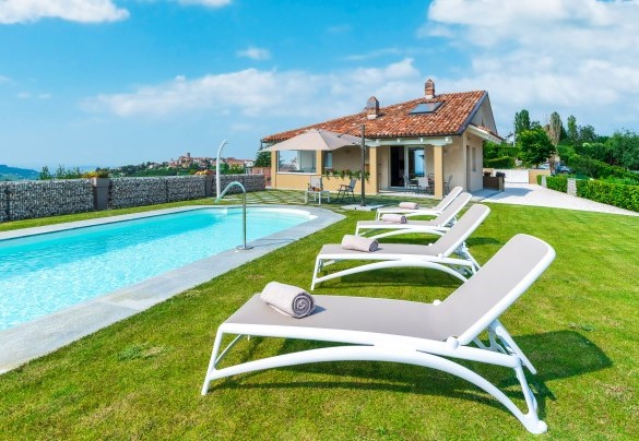 Il grande prato che circonda la piscina, corredato di lettini ed ombrellone si trasforma in solarium - Villa Tramonto Albese