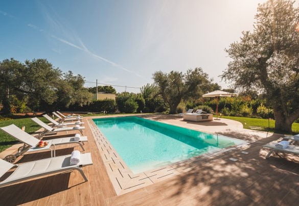 The large stoneware solarium that perimeters the pool at every angle -Trulli Biancapetra