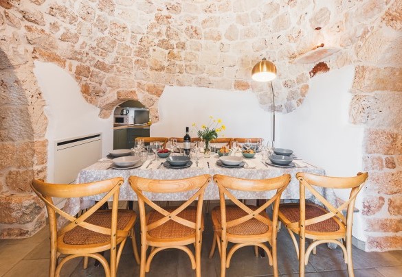 The dining table connected to the small kitchen -Trulli Biancapetra