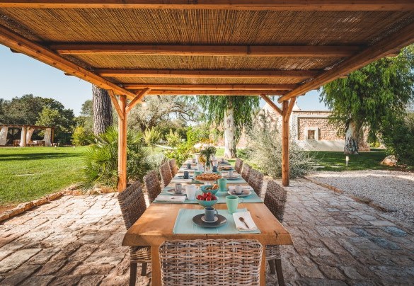 The table under the outdoor gazebo prepared for outdoor breakfasts -Trulli Biancapetra