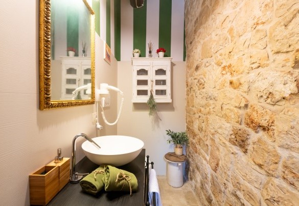 The en-suite bathroom in the master bedroom features a living stone wall  - Trulli Littoria