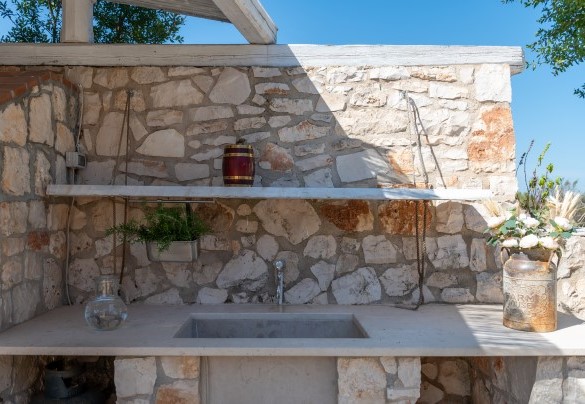 A distinctive stone sink next to the barbecue – Trulli Littoria