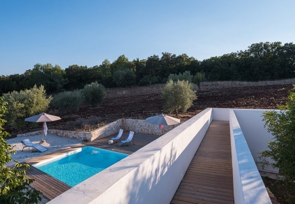 Il corridoio esterno che sovrasta la piscina immersa nel verde - Trulli Santa Pazienza