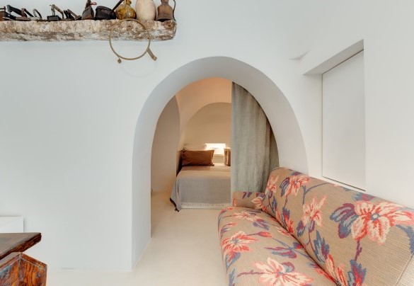Dalla zona pranzo dei trulli, un arco con tenda conduce alla camera matrimoniale n.2 caratterizzata da un letto divisibile inserito in una alcova - Trulli Santa Pazienza