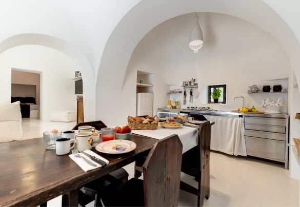La zona pranzo dei trulli è comunicante a sinistra con il salotto e con la camera matrimoniale n.1 e con il bagno con doccia - Trulli Santa Pazienza