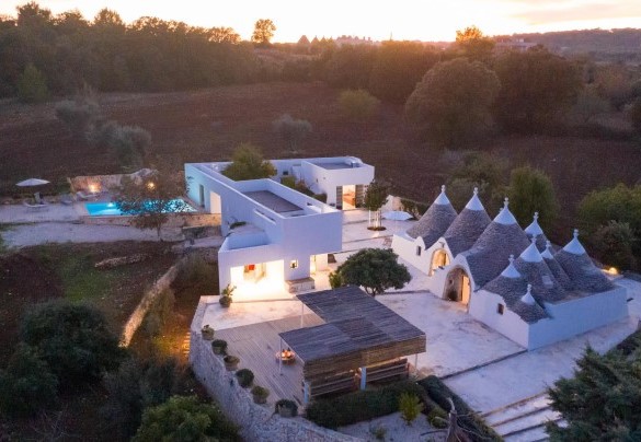 Nel suggestivo giardino che avvolge i tre corpi abitativi, le aree relax e pranzo si uniscono alla splendida piscina completando la proprietà - Trulli Santa Pazienza