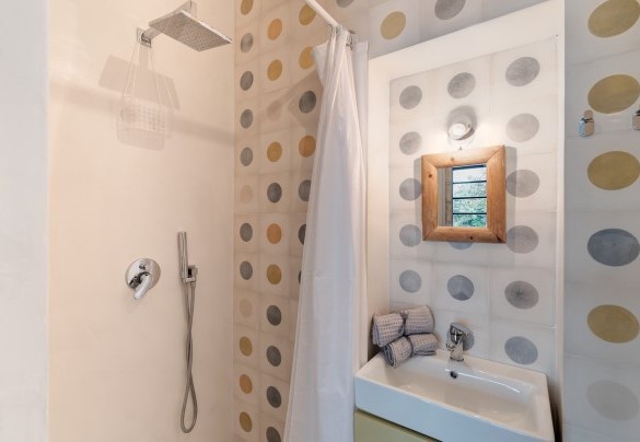 Il bagno con doccia della lamia dependance è colorato da allegre cementine sulle pareti - Trulli Santa Pazienza
