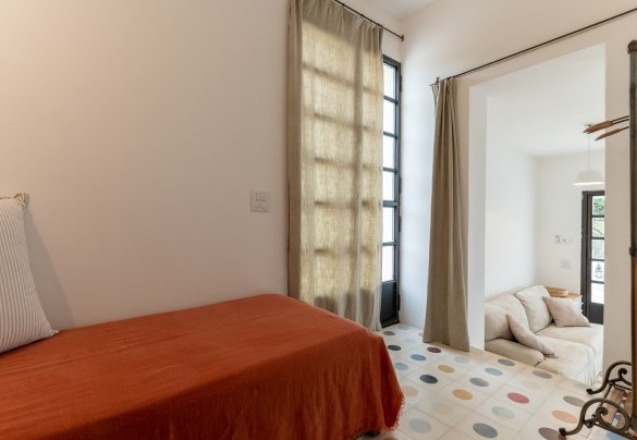 La stanza con letto aggiunto, separata dalla zona giorno da due gradini e da una tenda, può essere utilizzata come salottino - Trulli Santa Pazienza