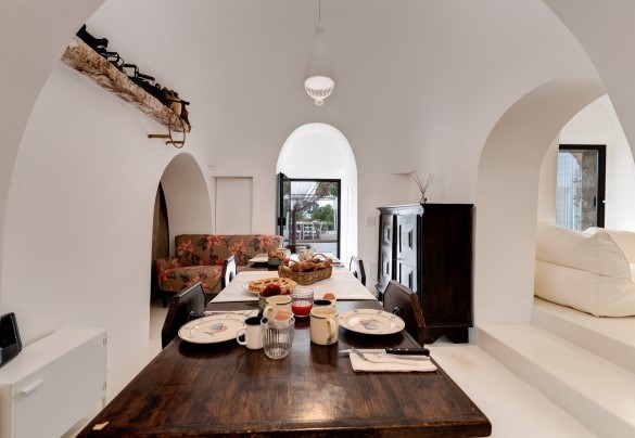 L'ingresso principale dei trulli immette nell'area pranzo ben collegata con la cucina in open space – Trulli Santa Pazienza