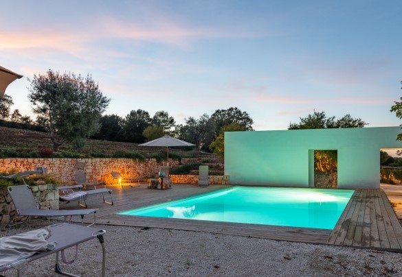 La piscina misura 8 x 4 e l'area prendisole si sviluppa tutto intorno grazie alla pavimentazione realizzata con assi in tek antiscivolo – Trulli Santa Pazienza