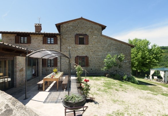 The outdoor dining area under the pergola, set up with table and benches - Val di Marco 