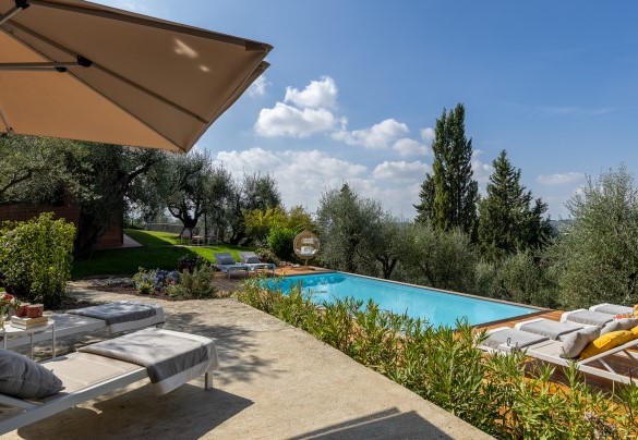 A corredo della piscina un solarium perimetrale in legno di Larice con comodi lettini, ombrelloni e doccia esterna - Villa Adisa   