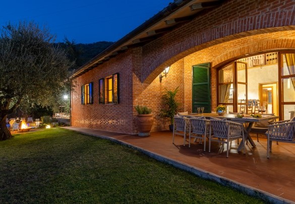Il giardino ben curato che circonda la villa illuminata - Villa Adisa  