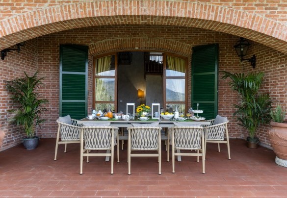 Il portico ombreggia l’elegante tavolo preparato per colazioni all’aperto - Villa Adisa  