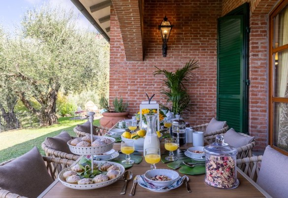 La zona pranzo esterna sotto il portico, allestito con tavolo e sedie - Villa Adisa   