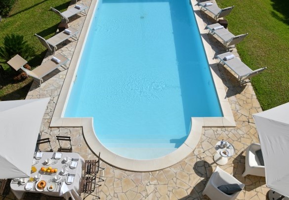 La piscina si trova al centro del giardino a livello con il piano terra della villa - Villa Afrodite 