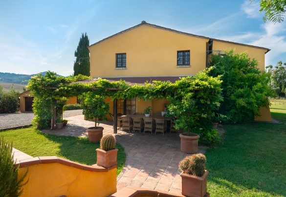 The outdoor dining area is adorned with climbing plants and flower pots, creating an ideal setting for summer dinners and convivial moments – Villa Allodola