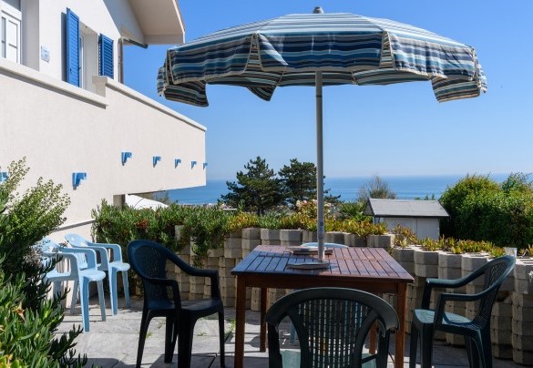 Table with umbrella and sea view – Villa Alma