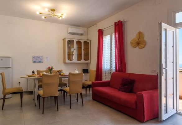 Living room with sofa and access to the sea-view balcony – Villa Alma