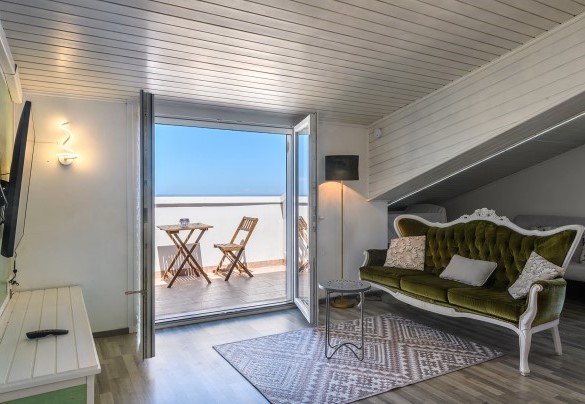 Attic living room with sofa and sea-view terrace – Villa Alma