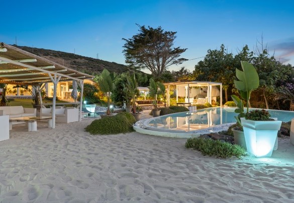 The swimming pool at sunset with a white sandy beach around it – Villa Ambra