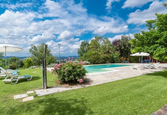 Area solarium attrezzata di lettini e ombrellone con la doccia fredda adiacente alla piscina - Villa Ambrah 12+1