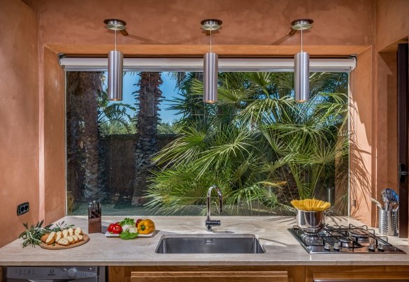 La cucina gode di serramenti vetrati che si fondono con il paesaggio circostante- Villa Antura