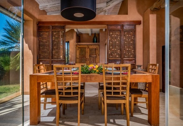 La sala da pranzo in open space gode di serramenti vetrati che si fondono con il paesaggio circostante - Villa Antura