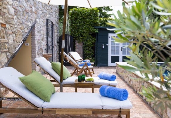 La terrazza della piscina attrezzata con lettini, sdraio e ombrellone - Villa Aperolli
