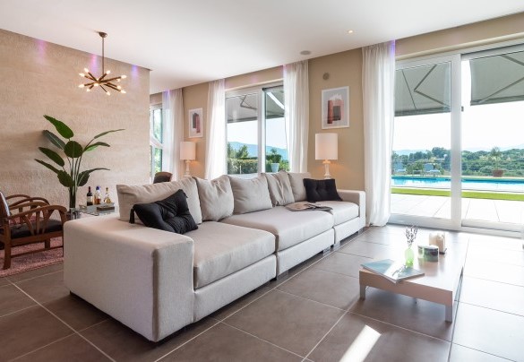 The living area with direct access to the outside, furnished with sofa, coffee tables and TV – Villa Atmosfere