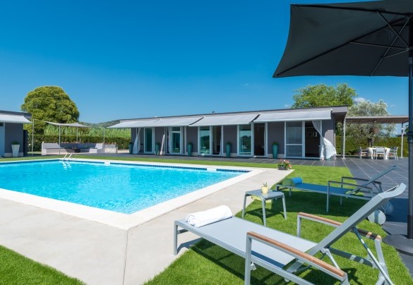 The large sliding glass French doors put the interiors and exteriors in constant communication, with shading curtains that allow you to experience the villa at any time of the day - Villa Atmosfere