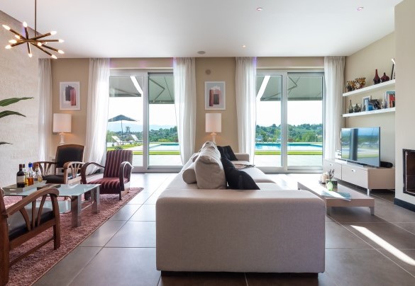 Bright living area, with shaded curtains and view of the pool – Villa Atmosfere