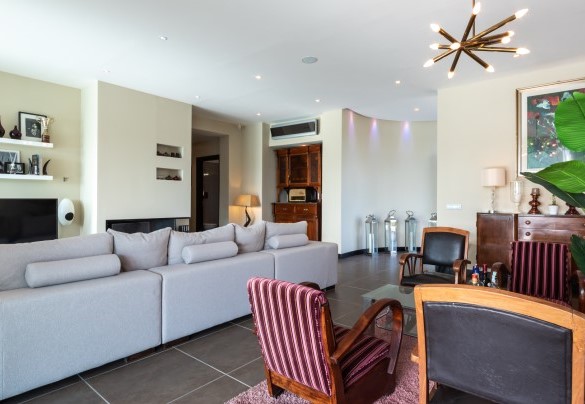 The living area with direct access to the outside, furnished with sofa, coffee tables and TV – Villa Atmosfere