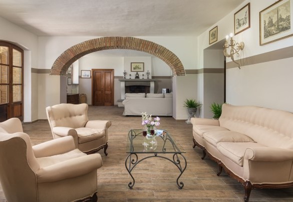 Salotto con ingresso principale con caminetto e divani - Villa Augusto
